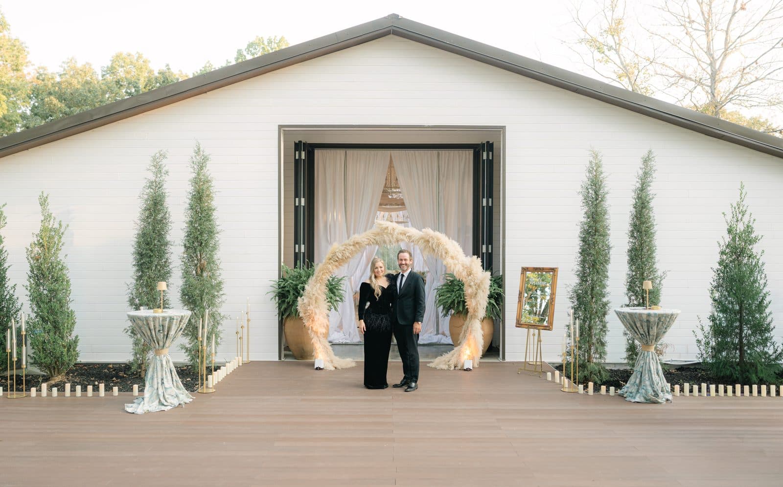 Olia Zavozina and Derek McFarlin beneath a floral arch at the Pavilion entrance